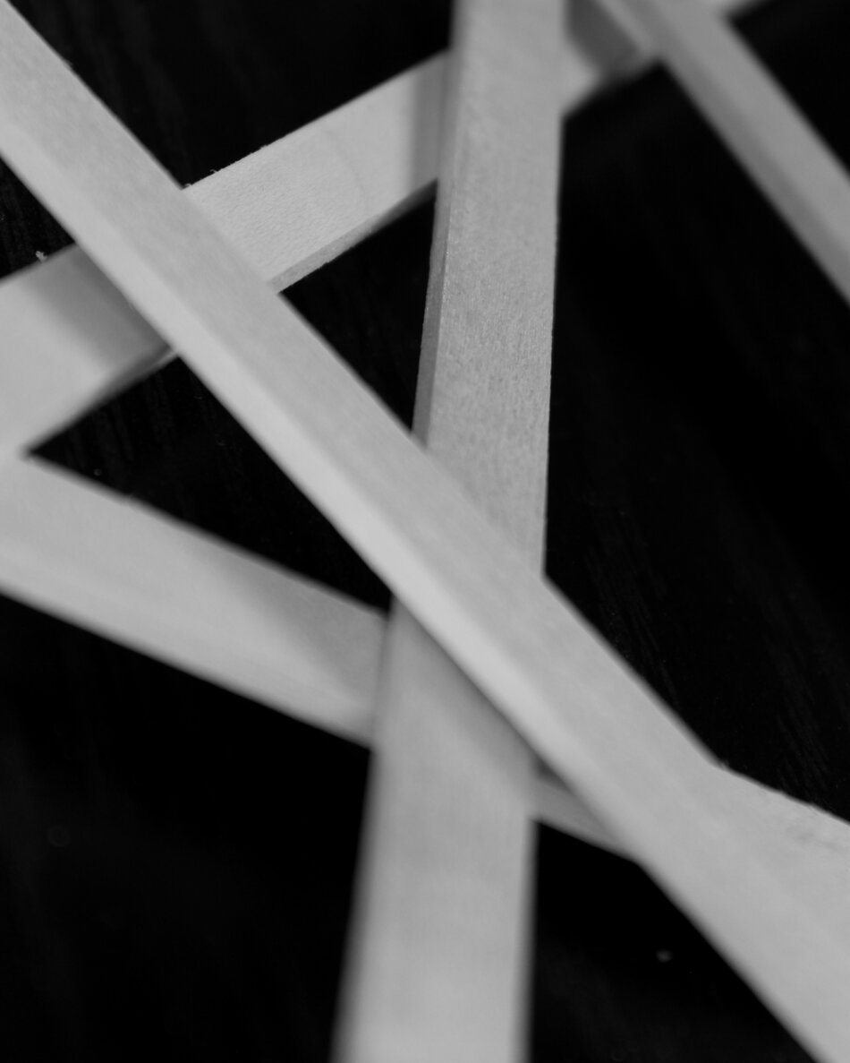 Close-up of linden wood sticks on a dark surface, showing the texture of the wood grain.